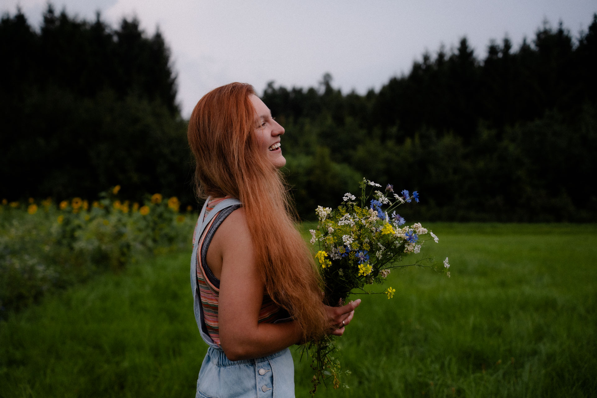 Lachende Frau in einem Blumenfeld, Portraitfotograf Augsburg
