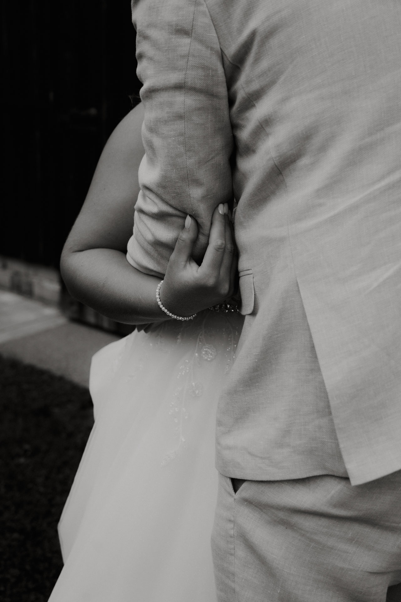 Ein monochromes Foto von dem Hochzeitspaar und wie sie sich in den Armen liegen.