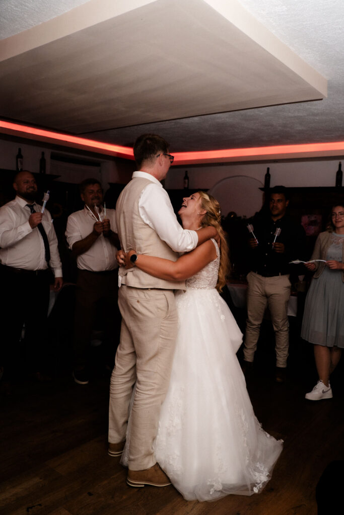 Das Hochzeitspaar tanzt zusammen, die Braut lacht froh.