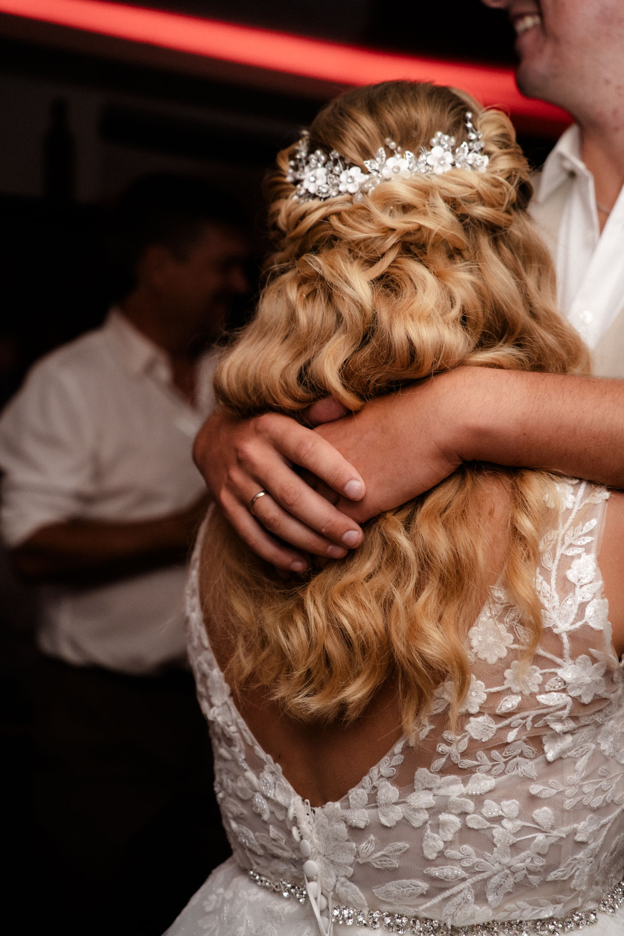 Die Hände des Bräutigams, wie sie beim Tanz über den Schultern seiner Braut liegen.