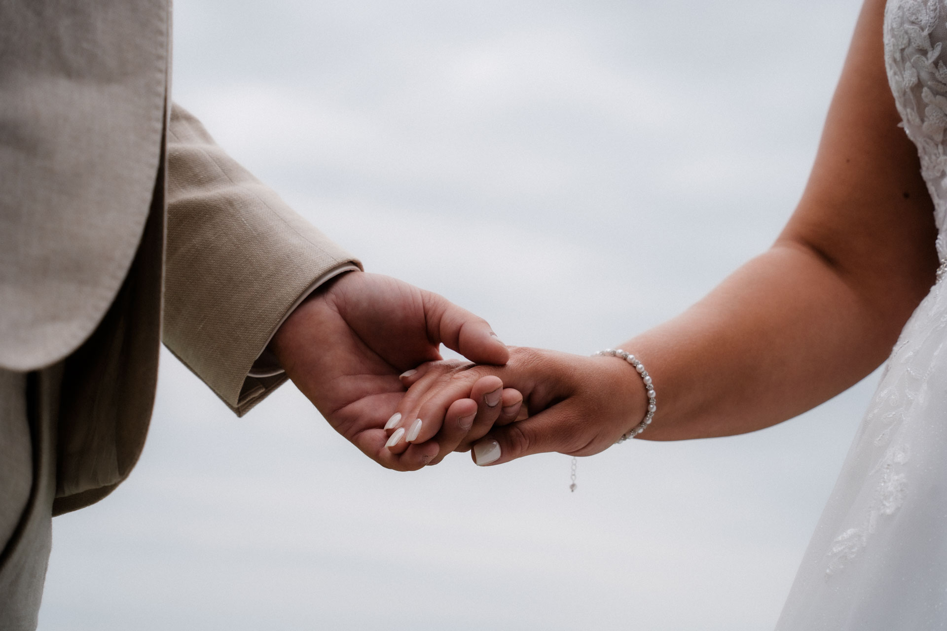 Braut und Bräutigam halten sich an den Händen.