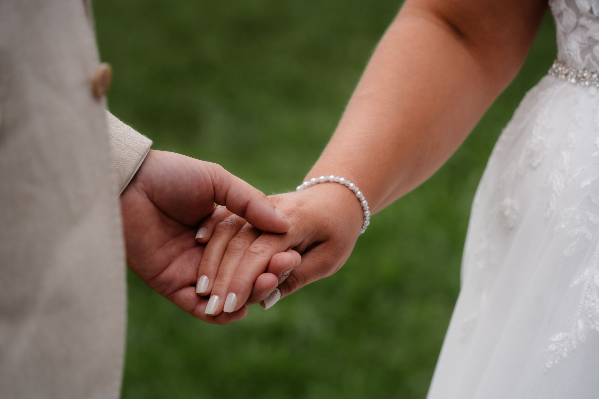 Braut und Bräutigam halten sich an den Händen.