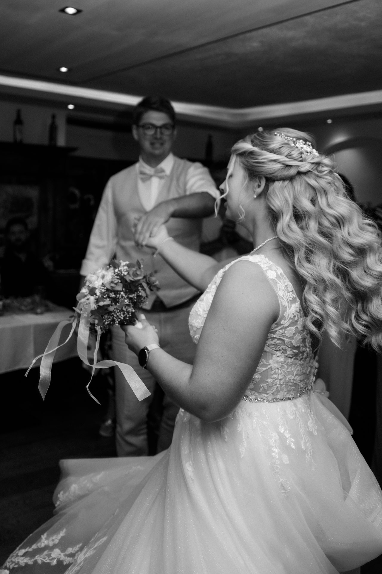 Der Bräutigam wirbelt seine Braut beim ersten Tanz durch den Saal.