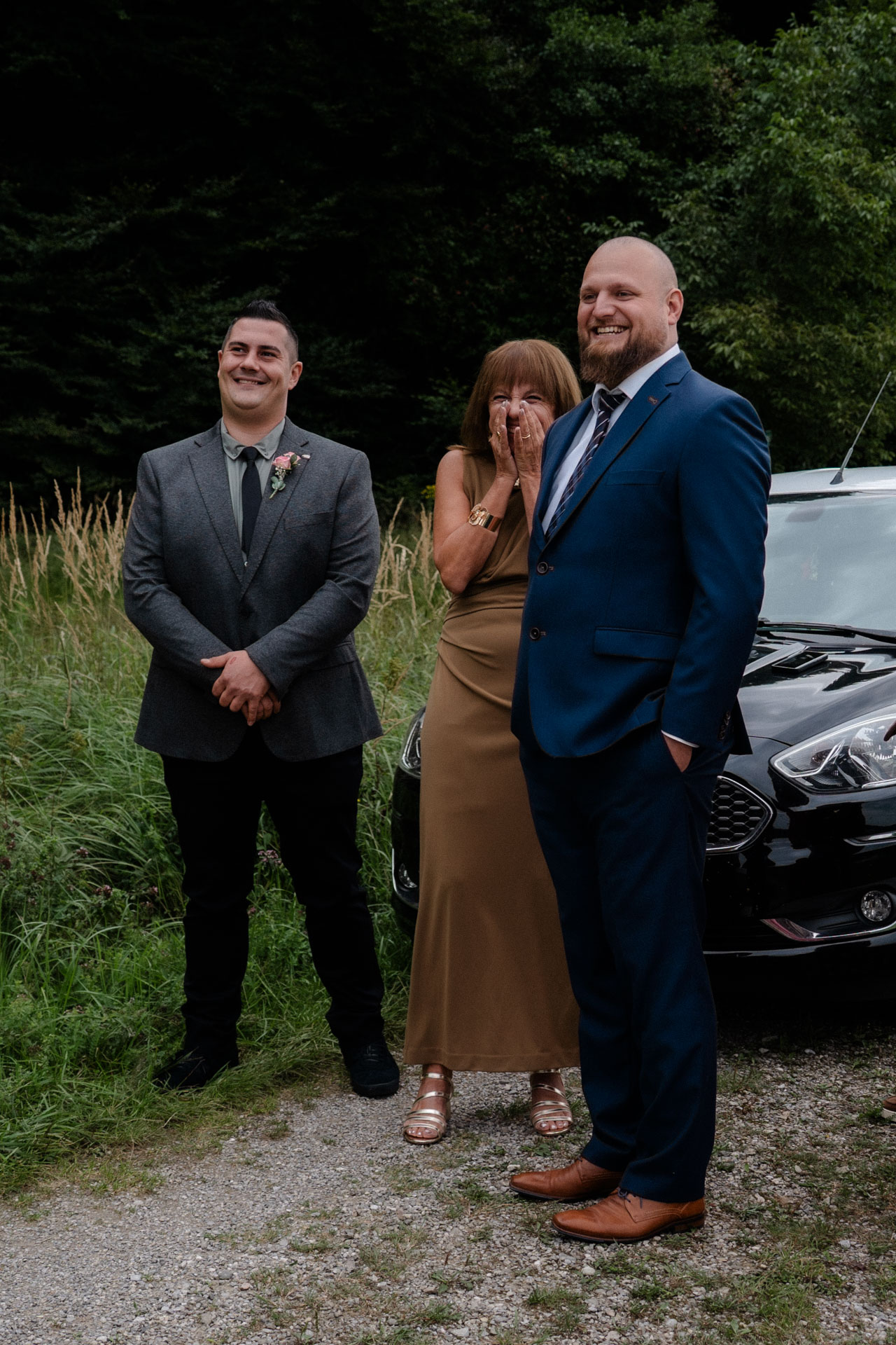 Zwei Männer und eine Frau die sich ungemein freuen, als sie die Braut zum ersten Mal sehen.