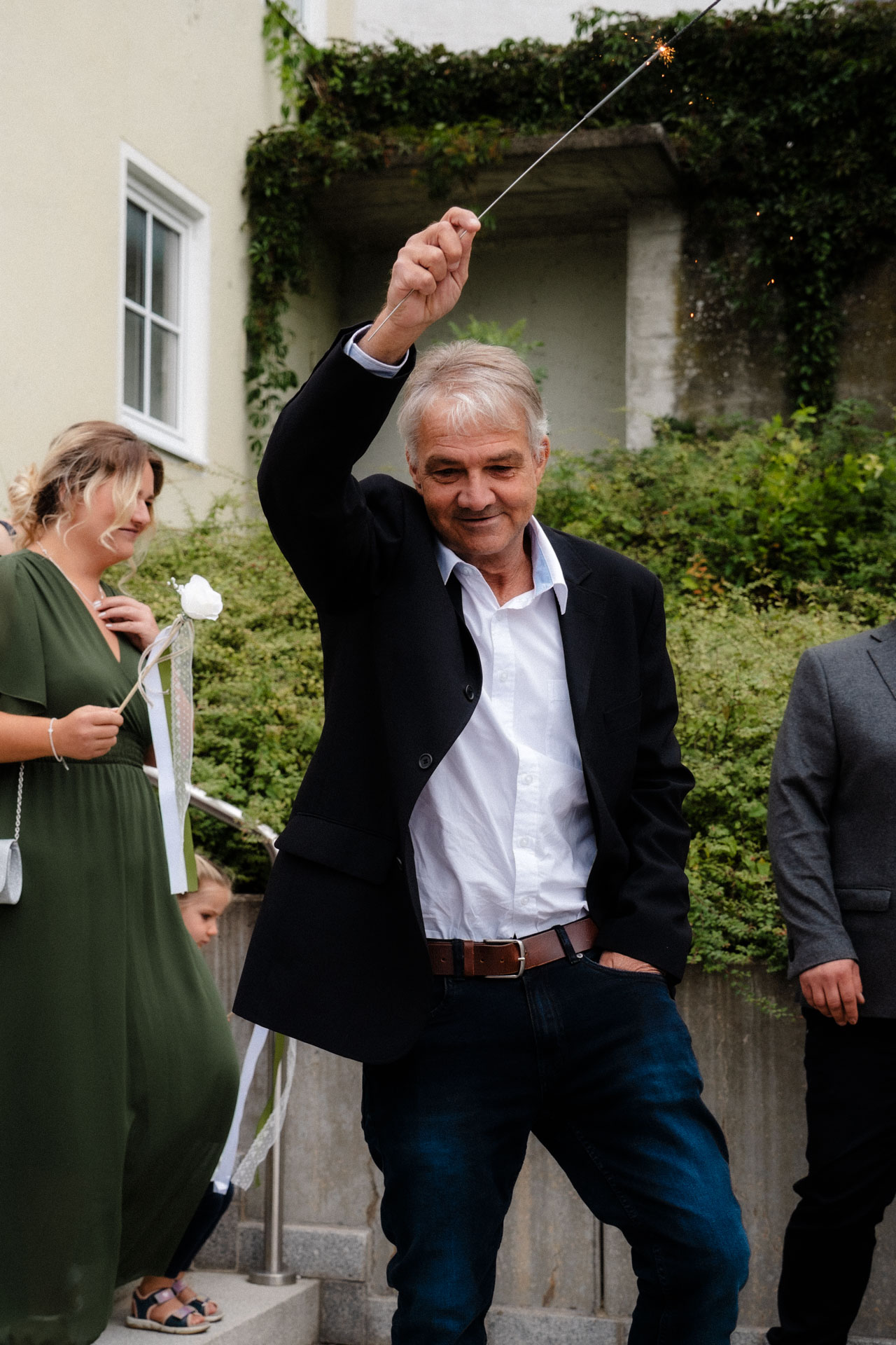 Ein Mann schwenkt eine Wunderkerze nach der Hochzeit.