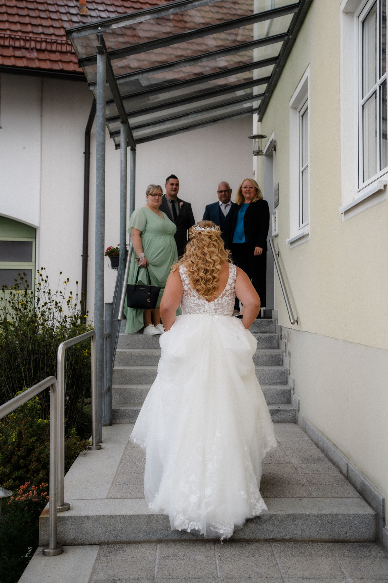 Die Braut von hinten und wie sie dem Standesamt entgegen eilt.
