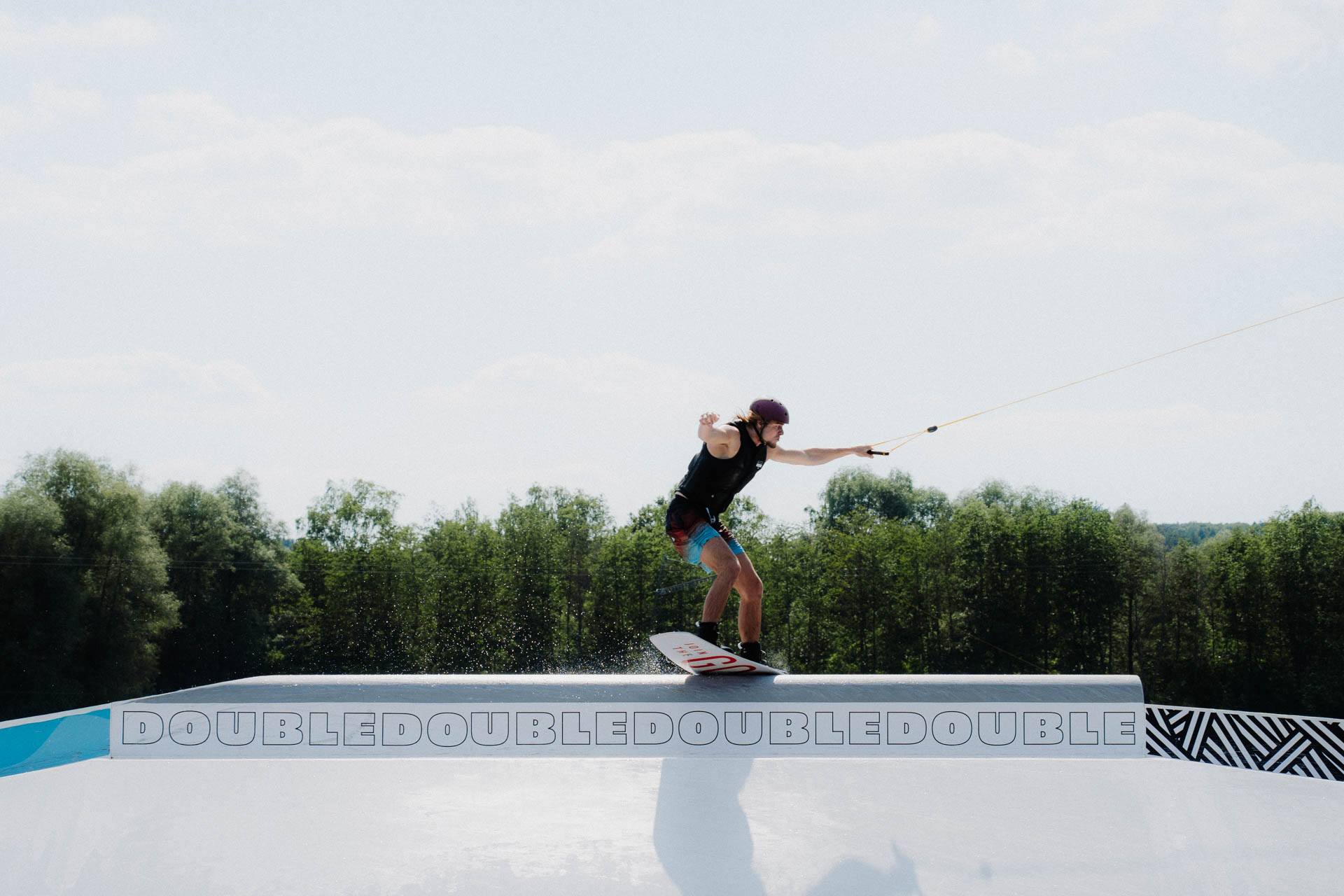 Wakeboarder auf einem Obstacle, ästhetisch in Szene gesetzt, das Foto ist im Rahmen der Event- und Sportfotografie entstanden. Thannhausen, Turncable
