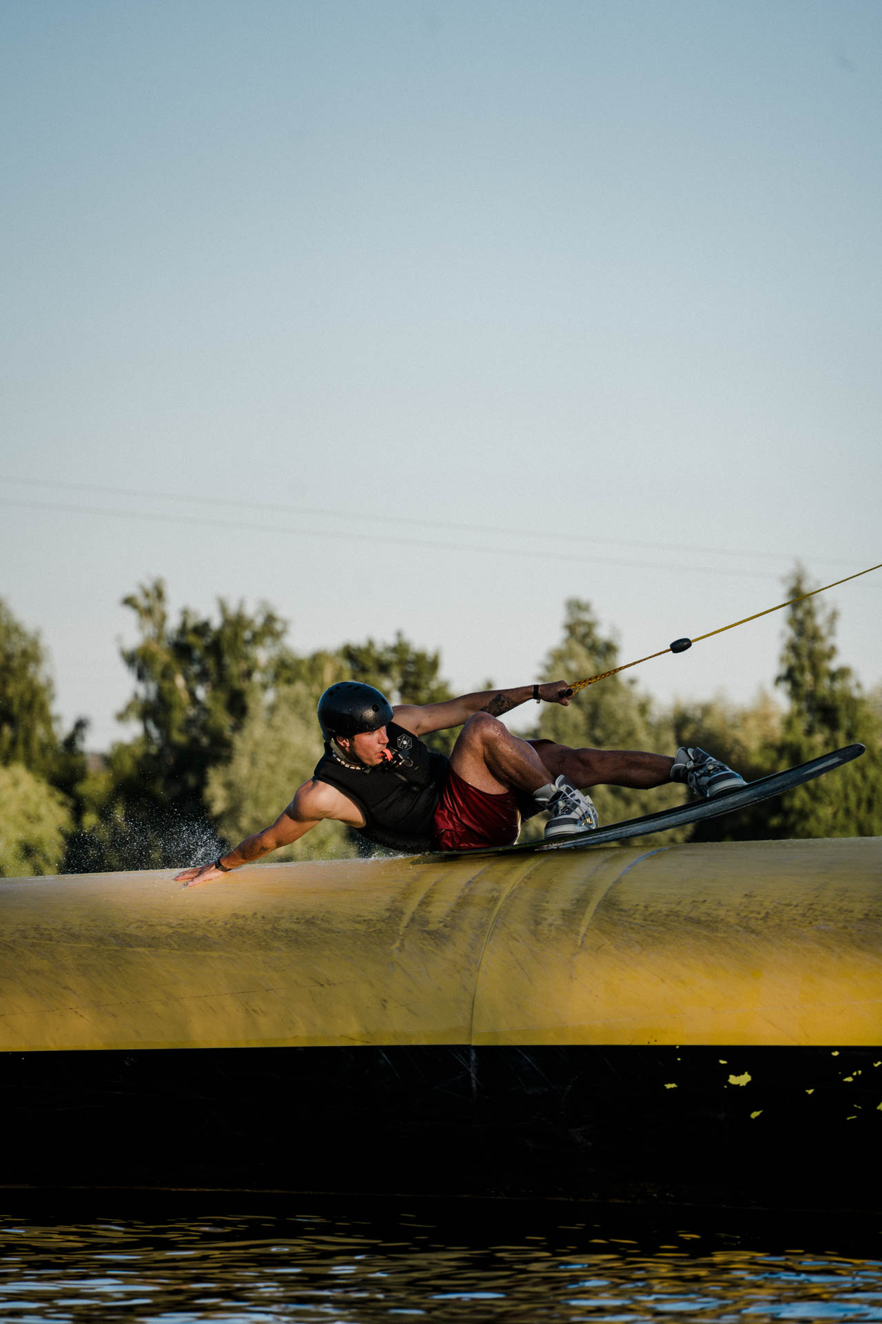 Wakeboarder auf einem Obstacle, ästhetisch in Szene gesetzt, das Foto ist im Rahmen der Event- und Sportfotografie entstanden. Thannhausen, Turncable