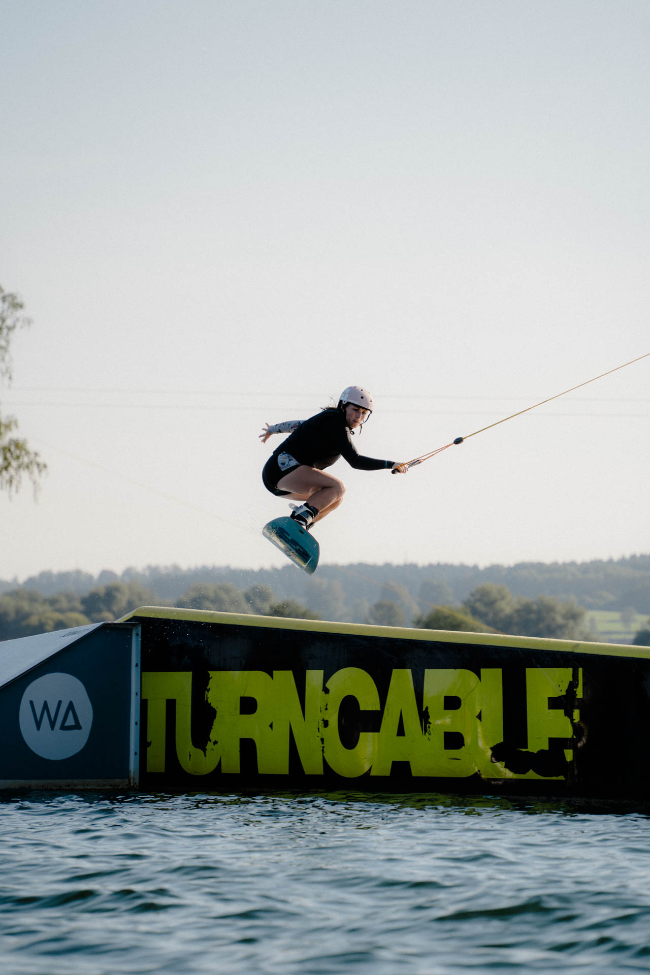 Wakeboarder auf einem Obstacle, ästhetisch in Szene gesetzt, das Foto ist im Rahmen der Event- und Sportfotografie entstanden. Thannhausen, Turncable