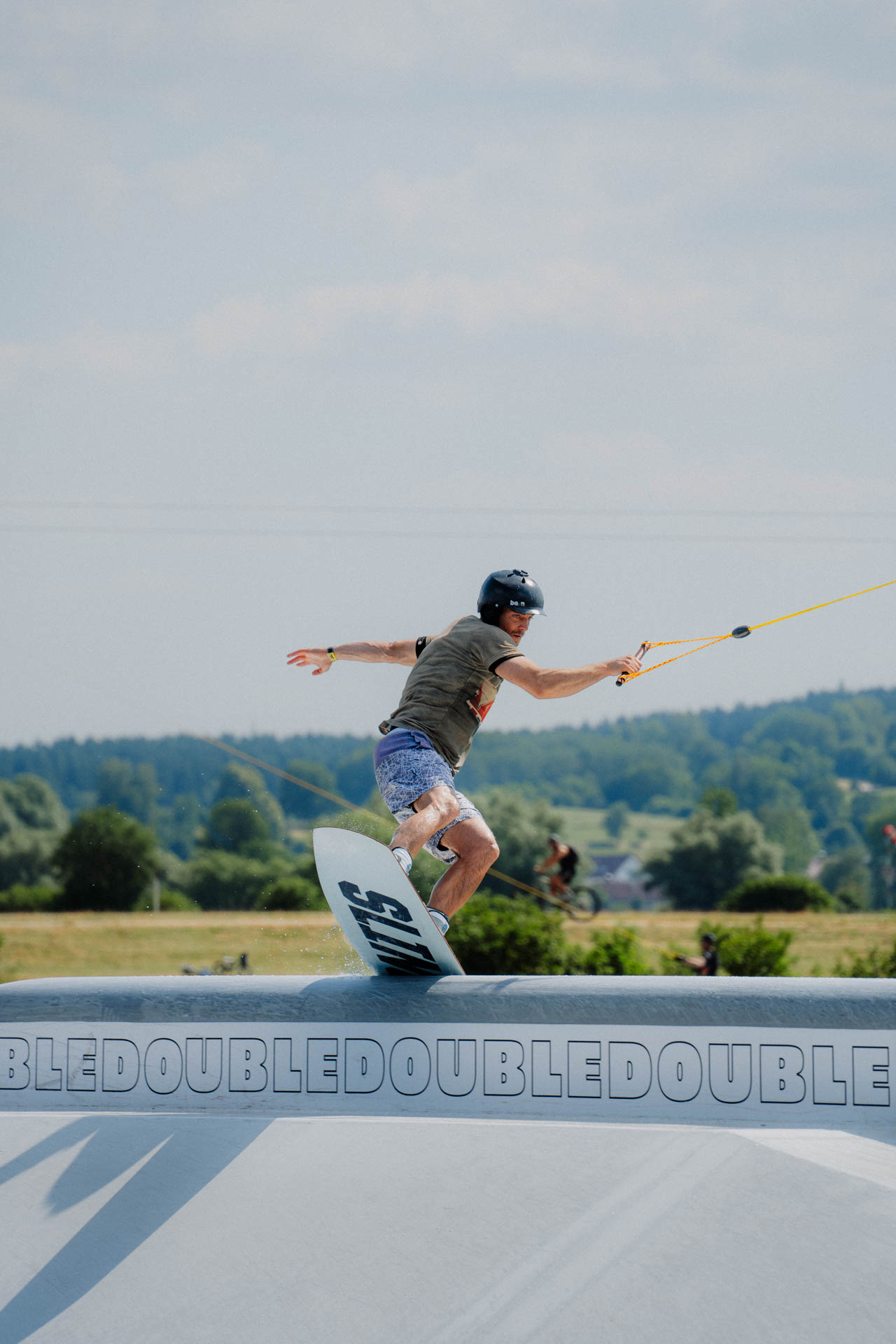 Wakeboarder auf einem Obstacle, ästhetisch in Szene gesetzt, das Foto ist im Rahmen der Event- und Sportfotografie entstanden. Thannhausen, Turncable