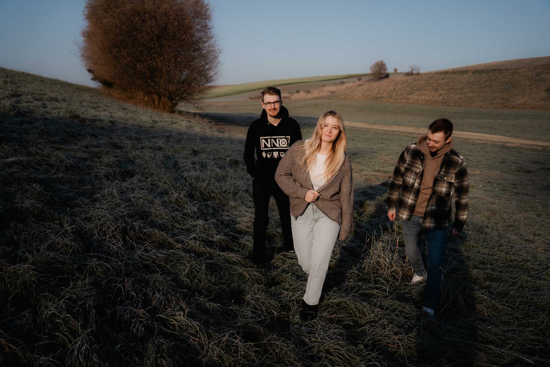 Drei Geschwister im herbstlichen Sonnenaufgang, das Foto ist im Rahmen der Familienfotografie entstanden