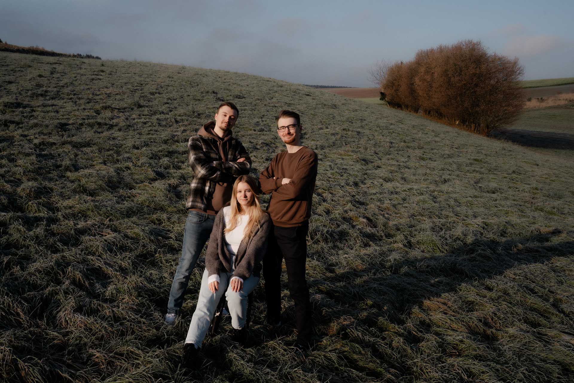 Drei Geschwister im herbstlichen Sonnenaufgang, das Foto ist im Rahmen der Familienfotografie entstanden