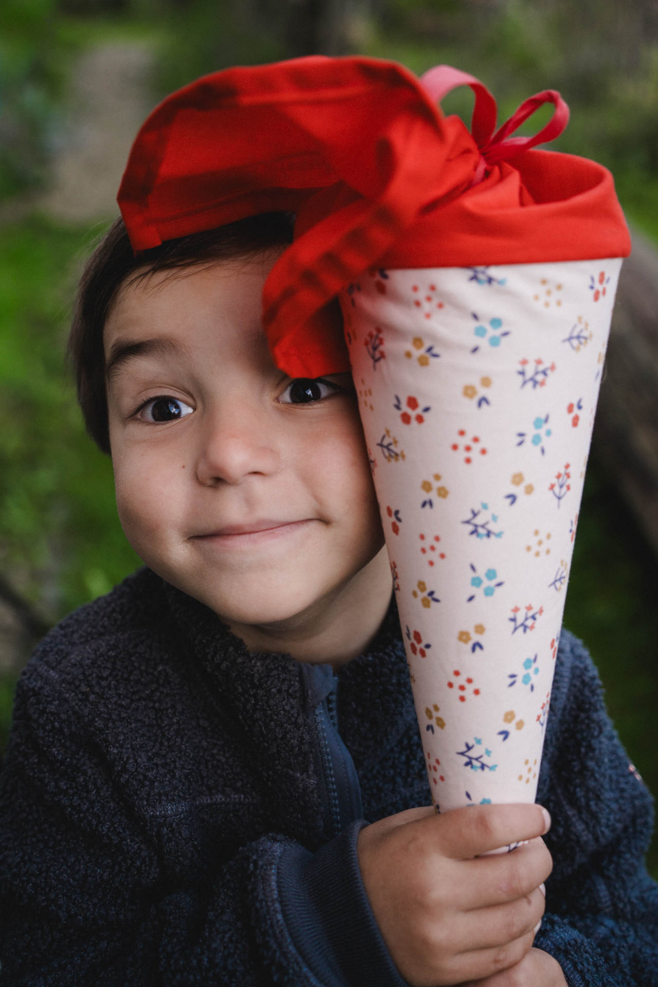 Das Foto eines Jungen mit Schultüte zur Einschulung, das Foto ist im Rahmen der Familienfotografie entstanden