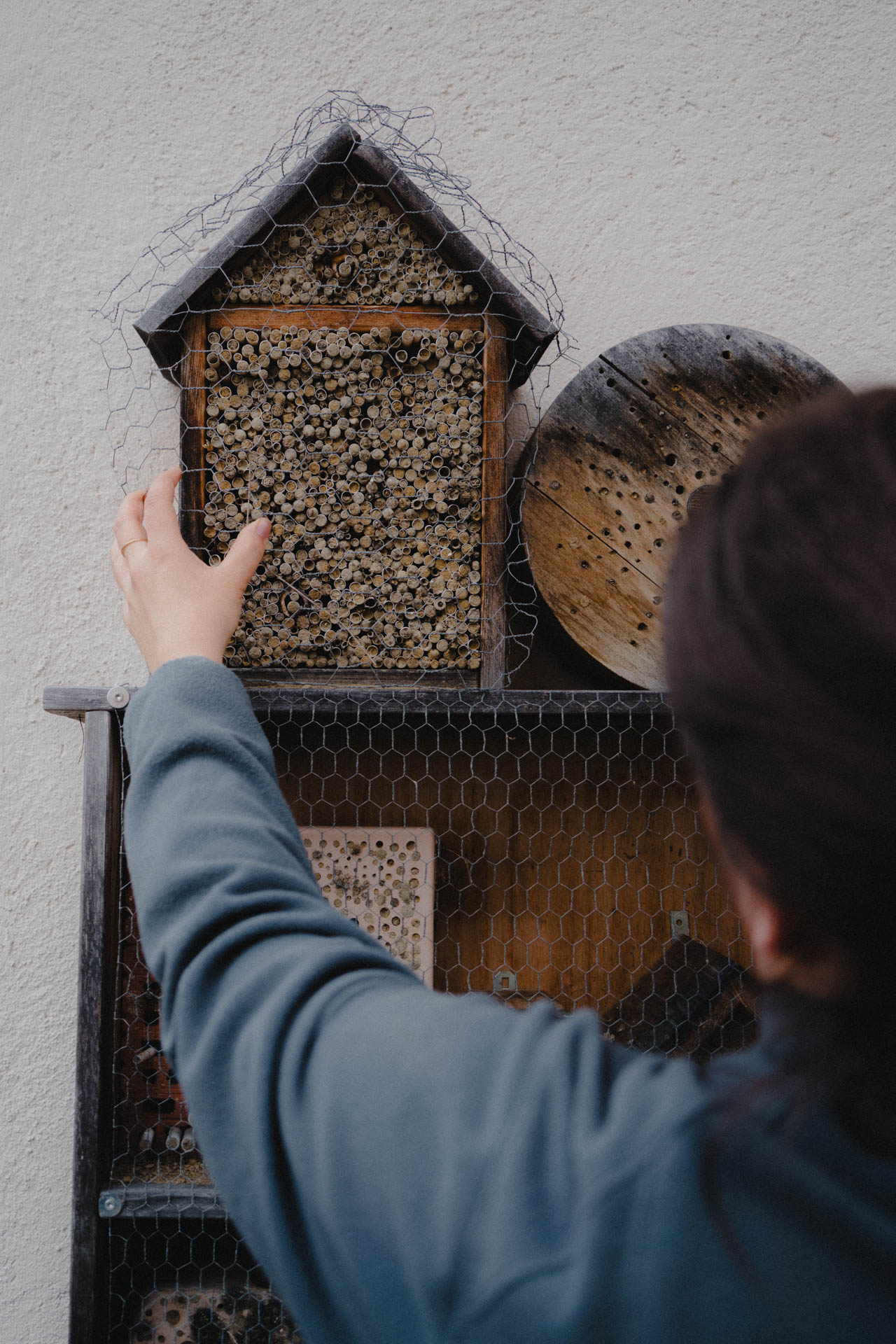Jemand sichert ein Insektenhotel vor Vögeln, das Foto ist im Rahmen einer Lifestyle Editorial Fotostrecke für Magazine entstanden