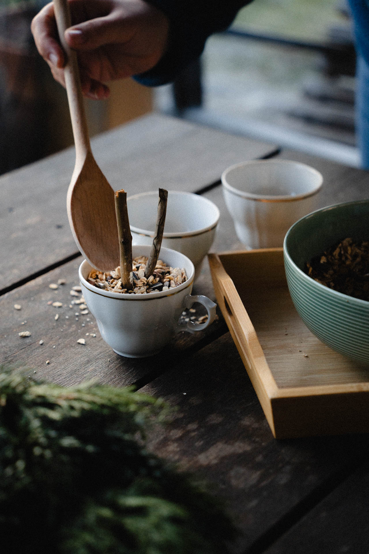 Eine Nahaufnahme davon, wie man Vogelfutter in Tassen zubereitet, das Foto ist im Rahmen einer Lifestyle Editorial Fotostrecke für Magazine entstanden, DIY Projekt