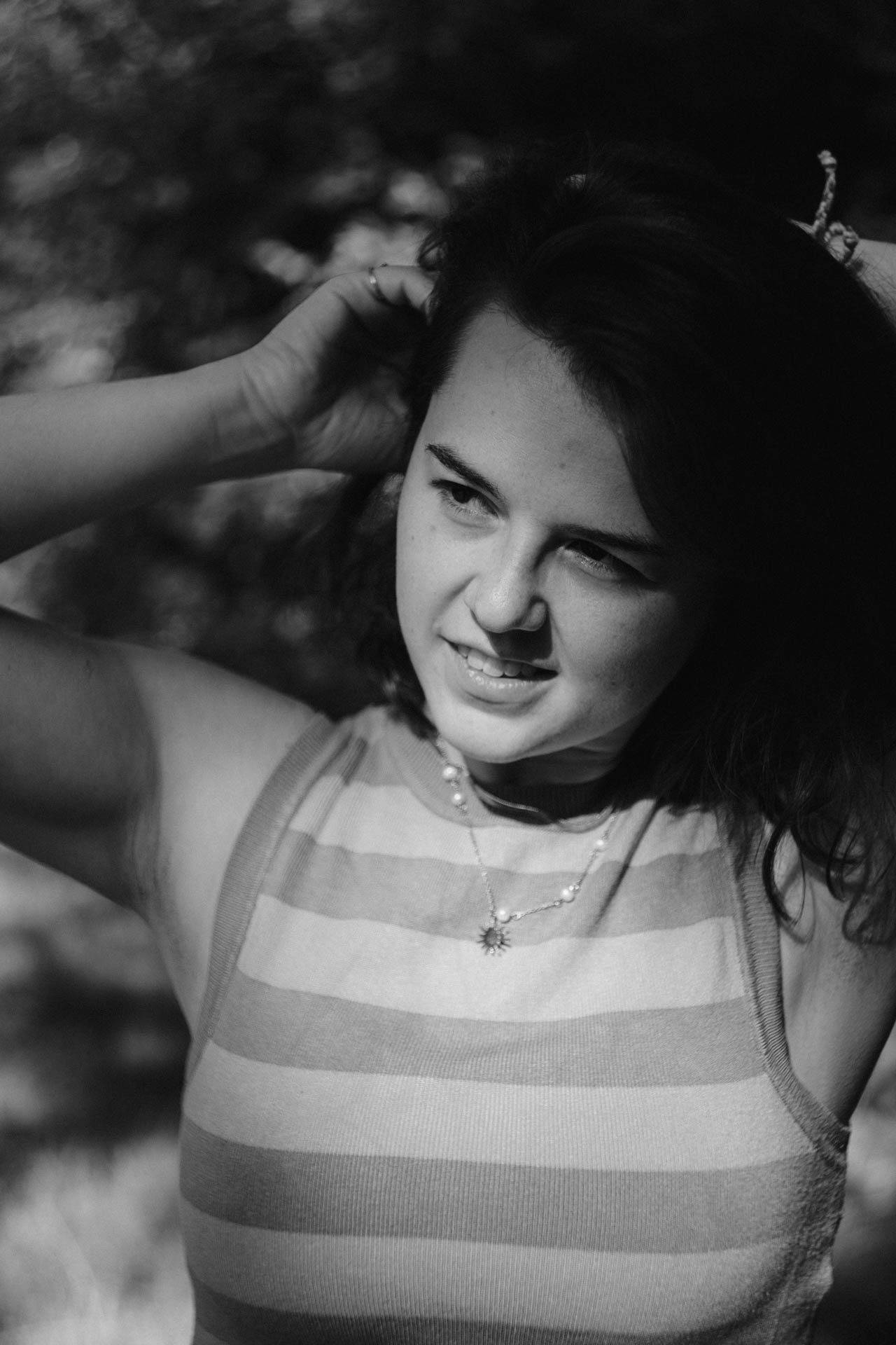 Das Foto einer Frau die ihre Haare richtet. Das Foto ist im Rahmen der Portraitfotografie entstanden.