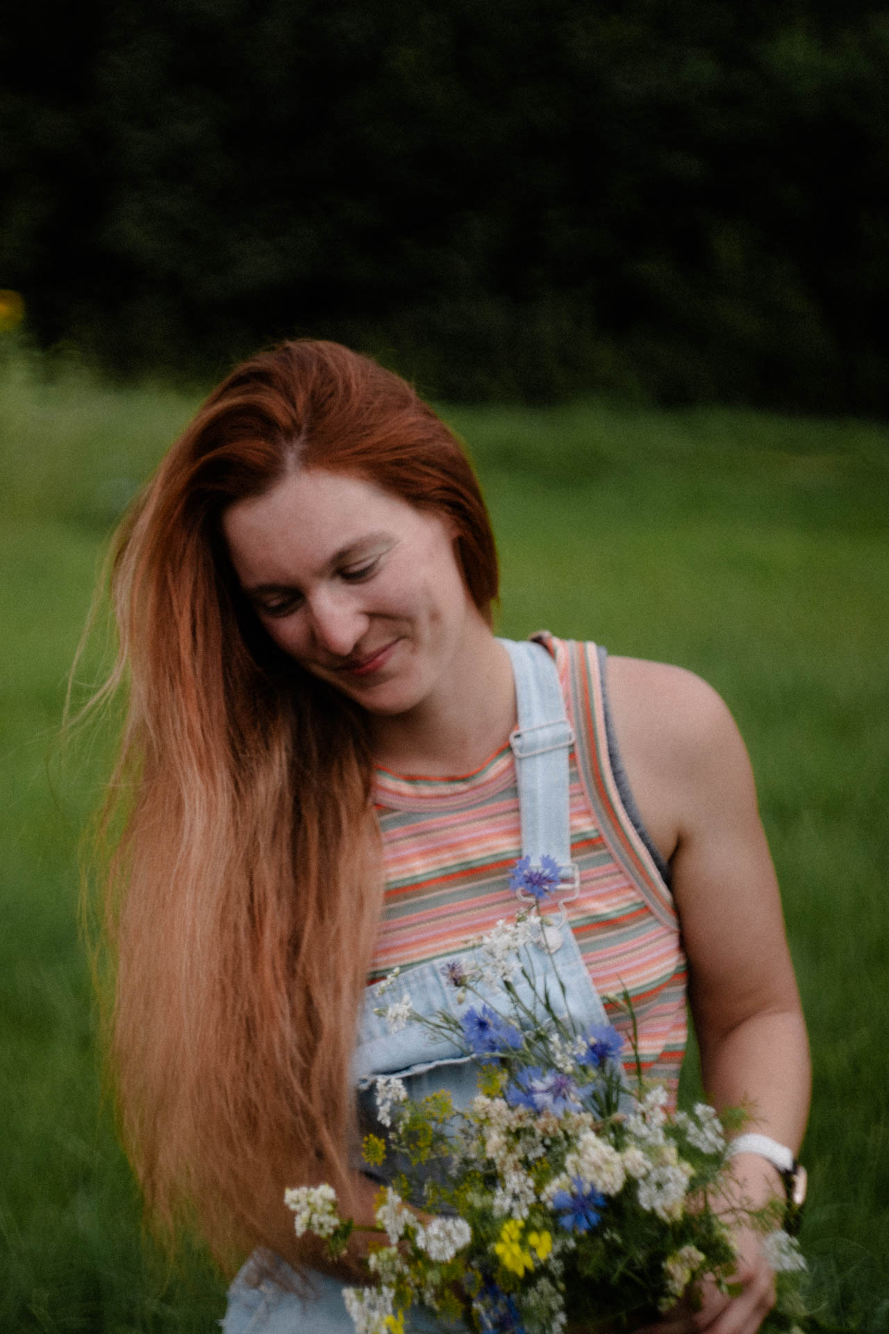Das Foto einer Frau mit einem Blumenstrauß in der Hand, das Foto ist im Rahmen der Portraitfotografie entstanden.