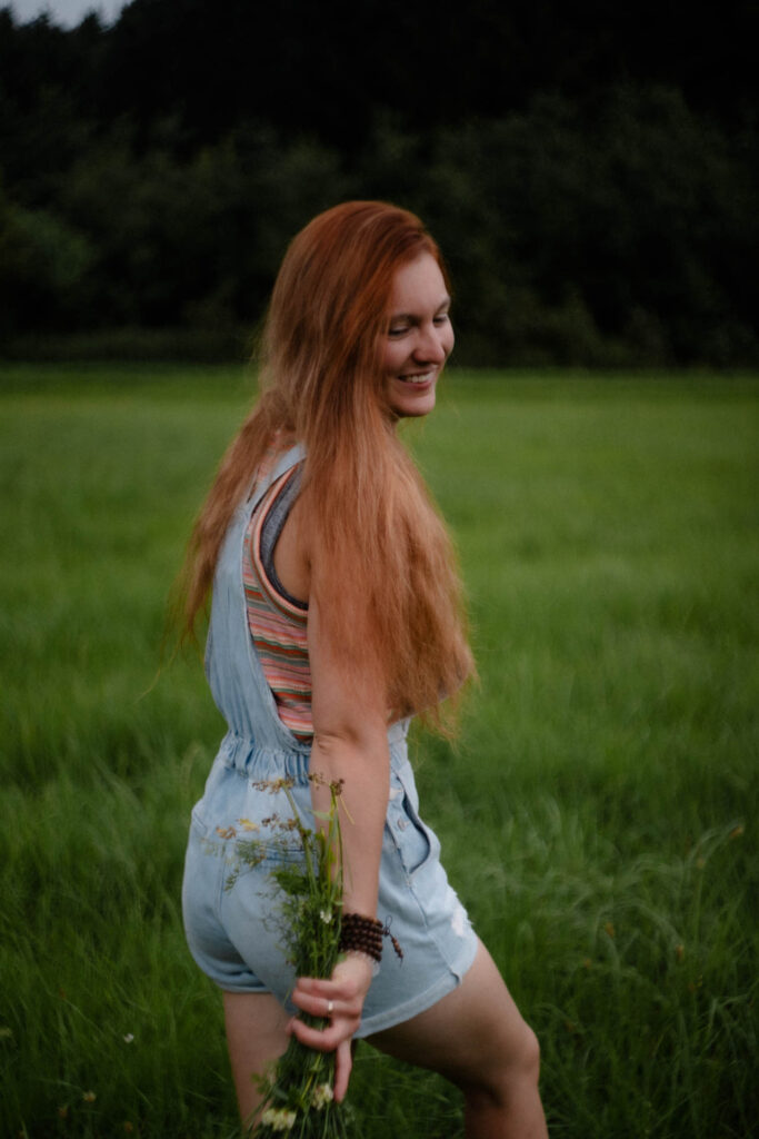 Eine Frau mit Blumenstrauß in der Hand, das Foto ist im Rahmen der Portraitfotografie entstanden.