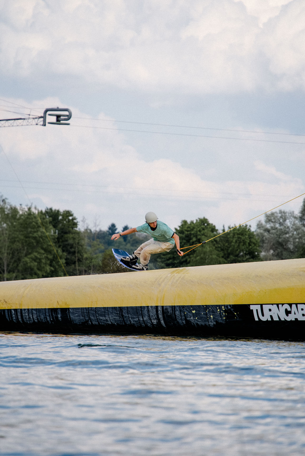 Wakeboarder auf einem Obstacle, ästhetisch in Szene gesetzt, das Foto ist im Rahmen der Event- und Sportfotografie entstanden. Thannhausen, Turncable
