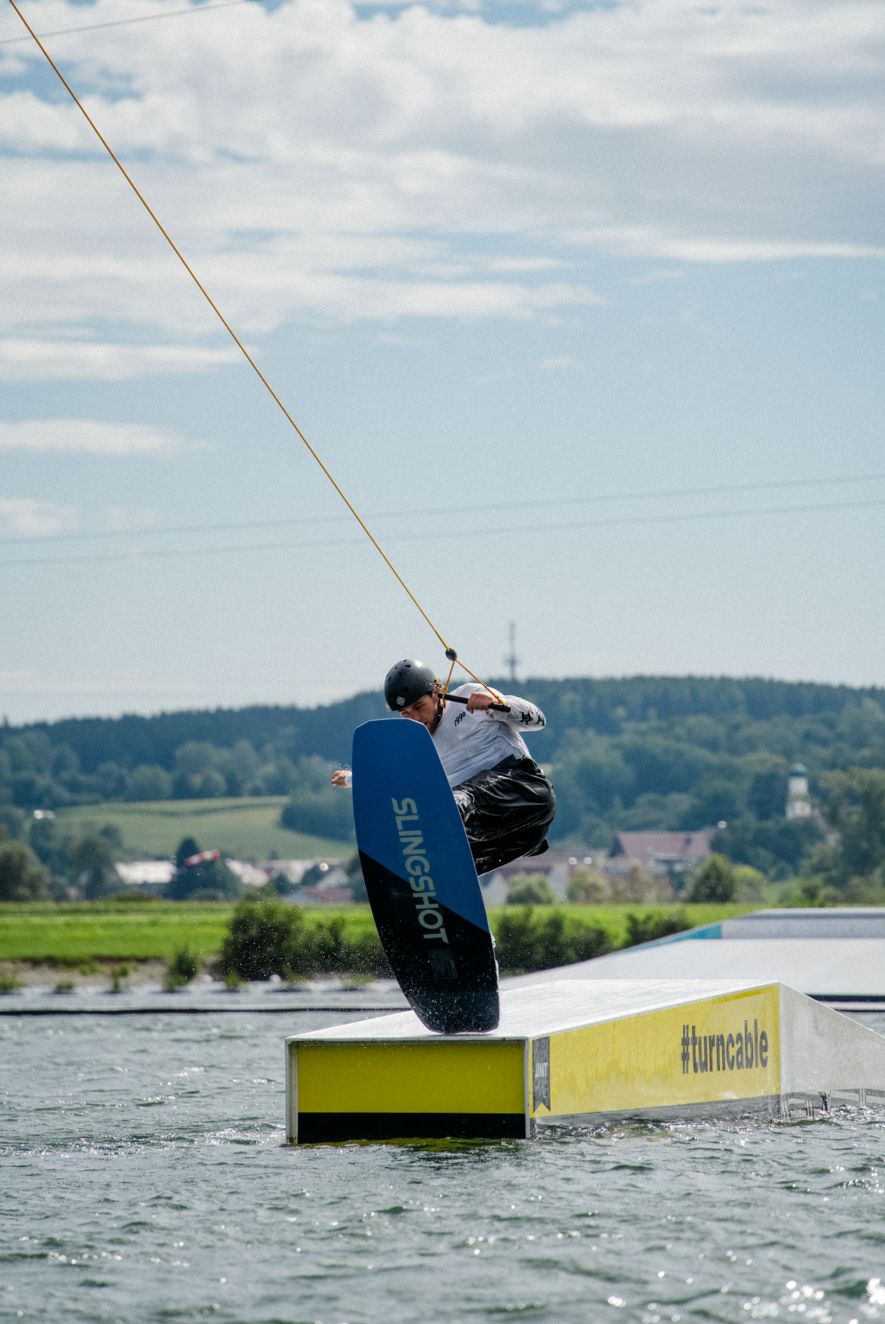 Wakeboarder auf einem Obstacle, ästhetisch in Szene gesetzt, das Foto ist im Rahmen der Event- und Sportfotografie entstanden. Thannhausen, Turncable