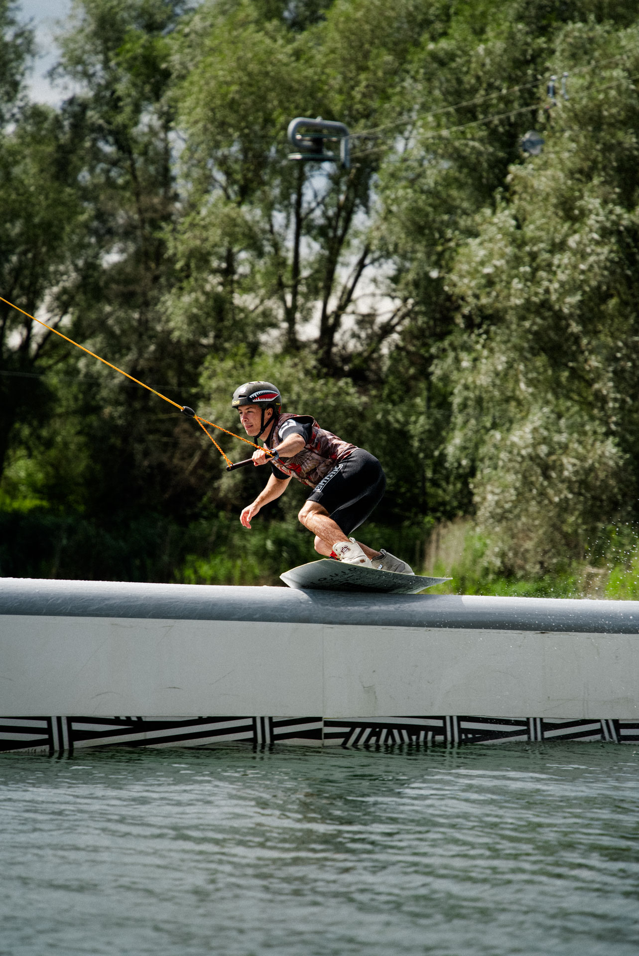 Wakeboarder auf einem Obstacle, ästhetisch in Szene gesetzt, das Foto ist im Rahmen der Event- und Sportfotografie entstanden. Thannhausen, Turncable