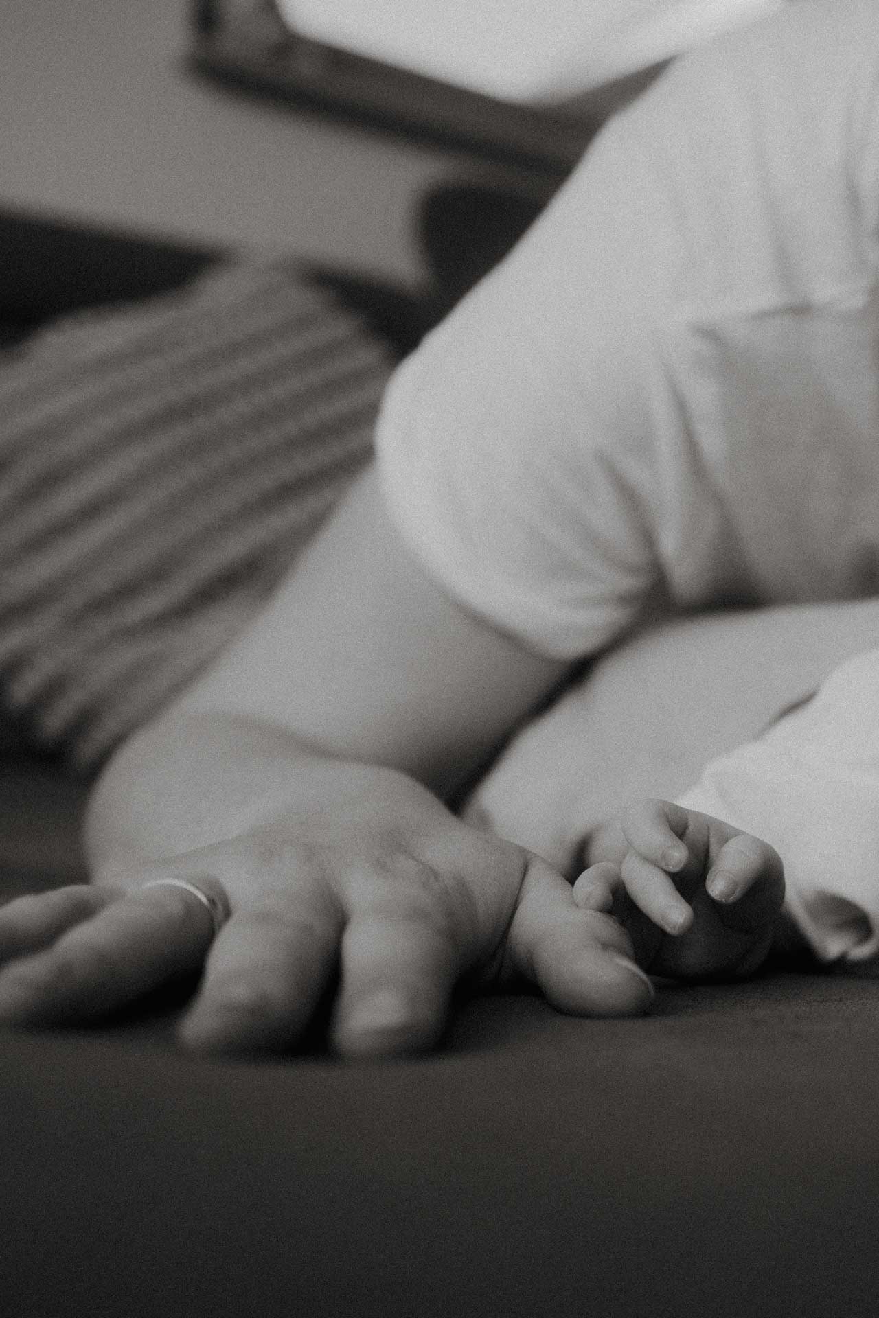 Die Hand einer Mutter und die ihres Kindes, das Foto ist im Rahmen der Newbornfotografie entstanden